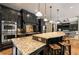 Charming kitchen features dark cabinets, pendant lights, stainless steel appliances, and a tiled backsplash at 908 Basingstoke Ct, Suwanee, GA 30024