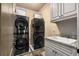 Well-organized laundry room with modern stacked washer and dryer units and ample storage at 908 Basingstoke Ct, Suwanee, GA 30024