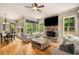 Cozy living room with hardwood floors, a stone fireplace, and large windows overlooking the yard at 908 Basingstoke Ct, Suwanee, GA 30024