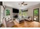 Inviting living room features a stone fireplace and large windows with wooded views at 908 Basingstoke Ct, Suwanee, GA 30024