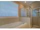 Bright bathroom features a soaking tub and separate glass-enclosed shower, enhanced by natural light at 1041 Flat Rock Rd, Covington, GA 30014