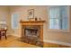 Cozy fireplace with wood trim and marble surround flanked by two windows for natural light at 1041 Flat Rock Rd, Covington, GA 30014