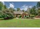 Well-maintained brick home with green lawn and mature trees on a sunny day at 1041 Flat Rock Rd, Covington, GA 30014
