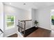Upstairs landing with dark wood floors, railing and view to another room at 350 Provenance Dr, Atlanta, GA 30328