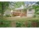 Spacious backyard with mature trees, multi-level deck, walkout basement, and patio, perfect for outdoor entertaining at 418 Whisper Wood Way, Locust Grove, GA 30248