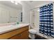 Bathroom features a single sink vanity and bathtub with a blue curtain at 418 Whisper Wood Way, Locust Grove, GA 30248