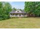 Traditional home with a large front yard and inviting covered porch at 418 Whisper Wood Way, Locust Grove, GA 30248