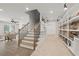 Bright hallway features wood stairs with iron railing and custom shelving for showcasing stone samples at 753 Brooke View Drive, Canton, GA 30115