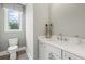Cozy powder room with gray walls, bright natural light, and a modern vanity with white countertop at 753 Brooke View Drive, Canton, GA 30115