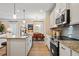 Open-concept kitchen with granite counters, stainless appliances, and adjacent living and dining areas at 22 Jacobs Farm Ln # 11, Lawrenceville, GA 30045