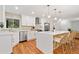 Bright modern kitchen boasts stainless appliances, wood floors, quartz counters, and a large island at 3222 Edgemont Way, Decatur, GA 30032
