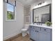 Stylish bathroom with gray cabinets, modern fixtures, a framed mirror, and a window at 327 Brooke View Trail, Canton, GA 30115