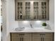 Butler's pantry features gray cabinets, glass displays, quartz countertops and stylish tile backsplash at 327 Brooke View Trail, Canton, GA 30115