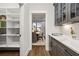 Charming butlers pantry featuring sleek cabinetry, designer hardware and a large pantry at 327 Brooke View Trail, Canton, GA 30115