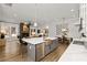 Open-concept kitchen featuring a large island with seating, stainless steel appliances, and an open view to the living room at 327 Brooke View Trail, Canton, GA 30115
