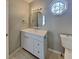 Well-lit bathroom featuring a vanity with storage, unique mirror, and eye-catching octagonal window at 4465 Kent Rd, Atlanta, GA 30337
