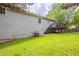 Exterior view of home with a deck and green grass lawn at 49 Sweetwater Ct, Powder Springs, GA 30127