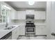 Bright kitchen boasts stainless steel appliances, white cabinets, and modern countertops for a sleek, functional design at 49 Sweetwater Ct, Powder Springs, GA 30127