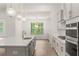 Bright and airy kitchen featuring modern appliances, a large island, and beautiful pendant lighting at 778 Brooke View Drive, Canton, GA 30115
