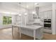 Well-lit kitchen with white cabinets, quartz counters, stainless appliances, and an island with seating at 778 Brooke View Drive, Canton, GA 30115