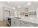 Bright open kitchen featuring a large island, stainless steel appliances, and a stone fireplace in the background at 778 Brooke View Drive, Canton, GA 30115