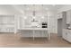 Spacious kitchen featuring white cabinets, a large island, modern appliances, and stylish pendant lighting at 778 Brooke View Drive, Canton, GA 30115