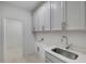 Well-appointed laundry room featuring ample cabinet space and a deep stainless steel sink at 778 Brooke View Drive, Canton, GA 30115