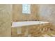 Elegant bathroom featuring a soaking tub with decorative window and marble-look tile at 2830 Scottish Mill Way, Marietta, GA 30068