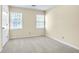Bright bedroom with neutral carpet, two windows, and a white door at 2830 Scottish Mill Way, Marietta, GA 30068