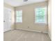 Cozy bedroom with neutral carpet, two windows, and a white door at 2830 Scottish Mill Way, Marietta, GA 30068
