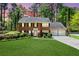 Charming brick home with a well-manicured lawn, mature trees, and an attached two-car garage at 2830 Scottish Mill Way, Marietta, GA 30068
