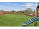 Expansive backyard featuring a playset, lush lawn, and privacy fencing at 4365 Sunflower Cir, Cumming, GA 30040