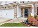 View of front door, 2 car garage, and flower garden of a traditional home with brick and white trim at 4365 Sunflower Cir, Cumming, GA 30040