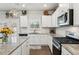 Modern kitchen with granite countertops, white cabinets, and stainless steel appliances offers a chef's delight at 4365 Sunflower Cir, Cumming, GA 30040