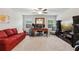 Cozy living room with a red sofa, carpeted floors, and a dedicated office area at 4365 Sunflower Cir, Cumming, GA 30040
