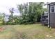 Large grassy backyard with mature trees, a neighboring home and a wooden fence at 1612 Branch Creek Cv, Lawrenceville, GA 30043