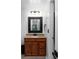 Cozy bathroom with a wood vanity, decorative mirror, and updated fixtures at 1612 Branch Creek Cv, Lawrenceville, GA 30043