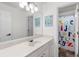 Bright bathroom with white vanity, large mirror, and tub/shower combo featuring a colorful alphabet curtain at 1612 Branch Creek Cv, Lawrenceville, GA 30043