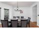 Formal dining room with hardwood floors, a modern chandelier, and a large dining table at 1612 Branch Creek Cv, Lawrenceville, GA 30043