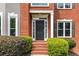 Close-up of the front door with brick facade and manicured landscaping at 1612 Branch Creek Cv, Lawrenceville, GA 30043