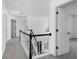Upstairs hallway with black and white banister, fresh paint, and new carpeting at 1612 Branch Creek Cv, Lawrenceville, GA 30043