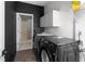 Laundry area with modern washer and dryer units, utility sink, and adjacent bathroom at 1612 Branch Creek Cv, Lawrenceville, GA 30043