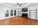 Spacious living room with hardwood floors, a fireplace, and large windows at 1612 Branch Creek Cv, Lawrenceville, GA 30043