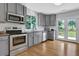 This bright kitchen boasts stainless steel appliances, gray cabinets, and a view of the backyard at 3411 Morgan Rd, Canton, GA 30115