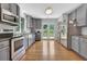 Updated kitchen features stainless steel appliances, granite countertops, stylish backsplash, and hardwood floors at 3411 Morgan Rd, Canton, GA 30115
