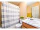 Well-lit bathroom with vanity, decorative plant, and white and blue shower curtain at 455 Lakeside Cir, Covington, GA 30016