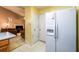 A kitchen area leads into a living room with tan walls and features a full-size refrigerator with an ice maker at 455 Lakeside Cir, Covington, GA 30016