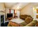 Living room features a fireplace, a ceiling fan, a tan sofa, and an entrance to the eat-in kitchen at 455 Lakeside Cir, Covington, GA 30016