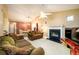 Spacious living room with fireplace, tan colored walls, and a ceiling fan with an attached dining room in view at 455 Lakeside Cir, Covington, GA 30016