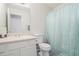 Bathroom with a single sink vanity with toilet and shower and mint shower curtain at 7835 Teton Trl, Douglasville, GA 30134
